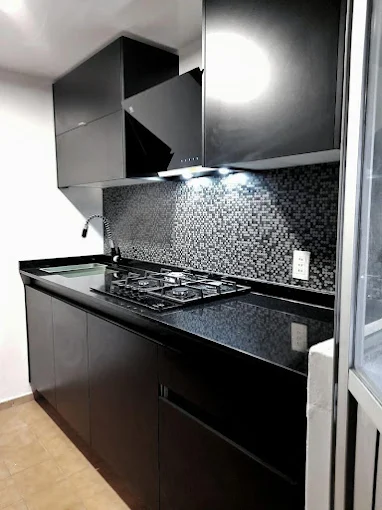 Cocina integral en acabado negro con cubierta de granito